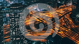 Busy Illuminated Road Intersection at Night among Modern Futuristic Buildings, Top View