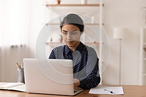 Busy indian lady freelancer typing electronic document text on pc