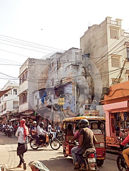 Busy Indian street with pedestrians, tuk tuks and motorcycles