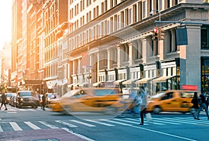 Busy intersection of 23rd Street and 5th Avenue with taxis and people during the rush hour commute in New York City