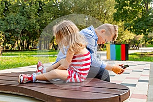 Busy kids looking at their phones texting sms and playing sitting outside