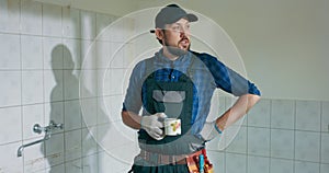 A busy laborer working on the renovation of a single-family house construction. Guy in work overalls baseball cap