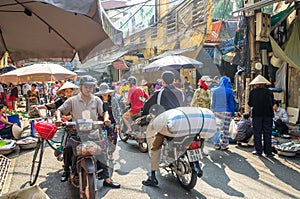 Busy local daily life of the morning street market in Hanoi, Vietnam. A busy crowd of sellers and buyers in the market.