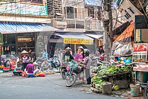 Busy local daily life of the morning street market in Hanoi, Vietnam. A busy crowd of sellers and buyers in the market.