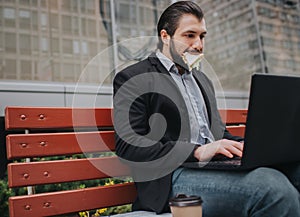 Busy man is in a hurry, he does not have time, he is going to eat snack outdoors. Worker eating and working with