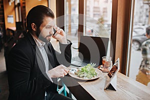 Busy man is in a hurry, he does not have time, he is going to eating and working. Worker eating, drinking coffee