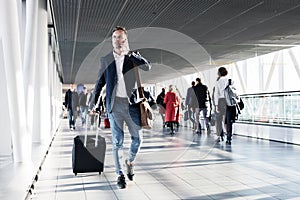 Busy man speaking on phone and walking in airport