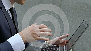 Busy man using laptop outdoors, technologies and constant access to work closeup
