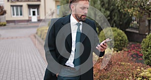 Busy man using smartphone while walking