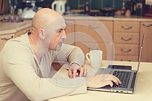 Busy man working at home. man sitting at home, working on laptop computer. man working from home laptop. Freelancer working from