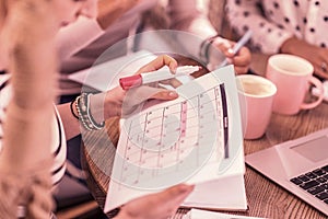 Busy master student holding pink marker while studying her new schedule