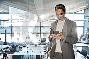 Busy mature business man wearing suit using mobile cell phone in office.