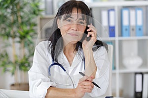 Busy medical doctor on phone with receptionist