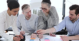 Busy mixed race colleagues analyzing marketing statistics.