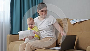 Busy mother tries to analyse reports holding baby daughter
