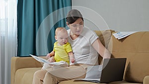 Busy mother tries to analyse reports holding baby daughter