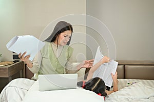 Busy mother trying to working at home, her daughter distracting from distance work