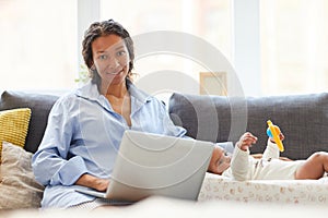 Busy mother working with laptop