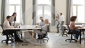 Busy multicultural employees working on computers in modern office rush