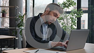 Busy multitasking caucasian businessman manager consultant talking on phone writing notes checking information on laptop