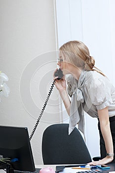 Busy office girl on landline phone call.