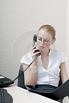 Busy office girl talking on phone.