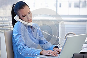 Busy office girl working with phone and computer