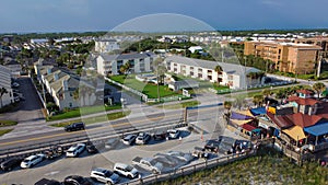 Busy parking lot near row of beach condominium, vacation rentals and restaurant along 98 Scenic Gulf Drive in Walton, Florida,