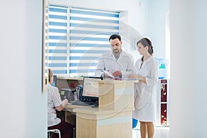 Busy reception in a hospital with doctors and receptionists