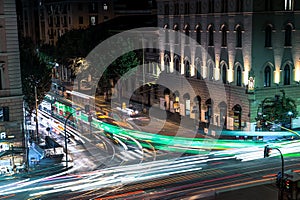 Busy Rome street with tram rides at night with light trail. Long exposure photo