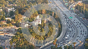 Busy rush hour intercity highway in metropolis, Los Angeles, California USA. Urban traffic jam on road in sunlight. Aerial view of