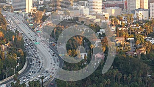 Busy rush hour intercity highway in metropolis, Los Angeles, California USA. Urban traffic jam on road in sunlight. Aerial view of