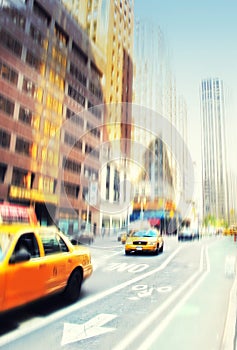 Busy scene with cars and taxis driving and traveling in blurred motion in the city. Commuting through a busy urban town