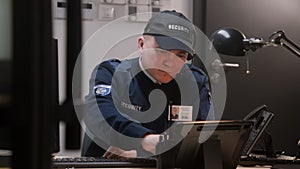 Busy security worker in headphones sits and typing keyboard