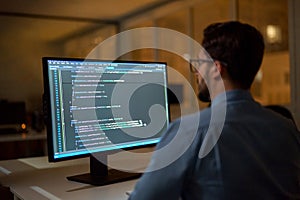 Busy business man software developer working on pc computer in office at night.
