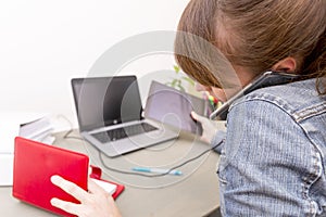 Busy stressed woman talking on a cell phone while using laptop a