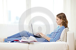 Busy teenage girl with laptop computer at home