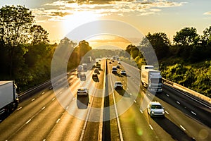 Busy traffic on uk motorway road overhead view at sunset