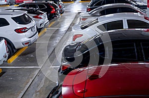 Busy underground car parking lot. Organized rows of vehicles in an urban hub. Urban convenience. Crowded parking space underground