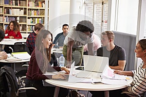 Busy University Library With Students And Tutor