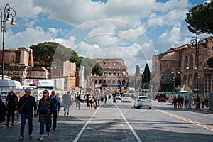Busy urban street with zebra crossing and ancient Roman Colosseum, Rome, Italy