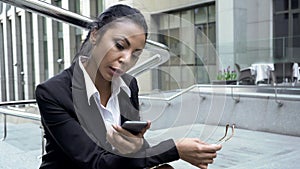 Busy woman checking e-mails on smartphone outdoors near office, lunch time