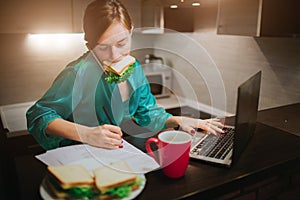 Busy woman eating, drinking coffee, talking on the phone, working on a laptop at the same time. Businesswoman doing