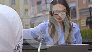 Busy woman feeding baby while working on laptop, difficult life of single mother