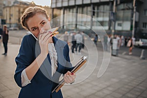 Busy woman is in a hurry, she does not have time, she is going to eat snack on the go. Worker eating, drinking coffee