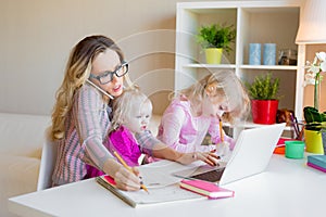 Busy woman trying to work while babysitting two kids photo