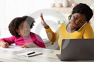 Busy Working African American Mother Ignoring Her Little Daughter Asking For Attention