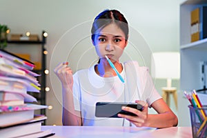 Busy Young Asian woman brushing teeth and hand playing online game on smartphone