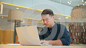 Busy young business man using laptop computer working sitting at office desk.