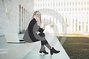 Busy young business woman talking on her mobile phone